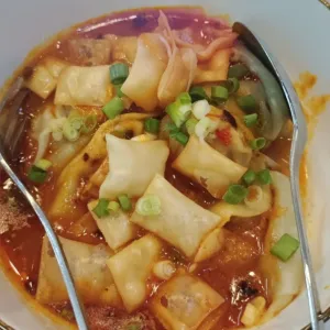 Wonton kuah Saus + Chili Oil1 porsi isi 5, level pedas standar dengan kuah saus racikan dan Chili Oil toping taburan kulit pangsit goreng